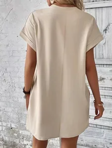 Vista posteriore di un miniabito beige a girocollo con maniche corte e tasche laterali