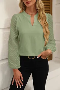 Close-up detail of an elegant light green chiffon blouse featuring lace sleeves