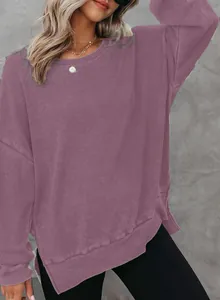 Detail van een mauve wafelgebreide sweater met zijsplit en textuur van de stof.