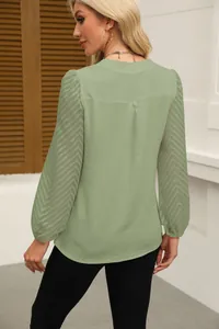 Back view of a sage green chiffon blouse featuring elegant lace patchwork sleeves.