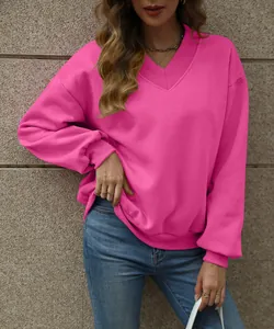 Detail view of a vibrant pink V-neck sweatshirt with soft fleece texture and rib cuffs.