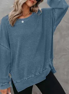 Detail van blauwe wafelgebreide sweater met ronde hals en zijsplitjes voor dames