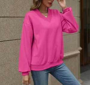 Detail of a bright pink V-neck oversized fleece sweatshirt for women in outdoor setting