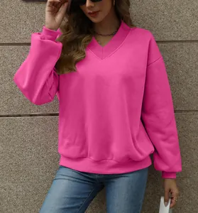 Close-up detail of women's vibrant hot pink V-neck oversized fleece sweatshirt