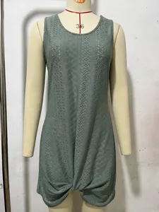 Detailed view of the hollow-out knit texture and twist hem on a green beach dress.