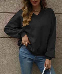 Close-up of a women's oversized black V-neck sweatshirt with ribbed cuffs and hem.