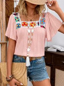 Détail de la blouse rose boho avec encolure carrée et broderie au crochet