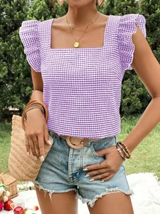Close-up of purple gingham square neck top with ruffle sleeves in a lush outdoor setting