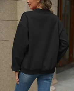 Detailed back view of a minimalist black loose-fit sweatshirt for women in outdoor setting