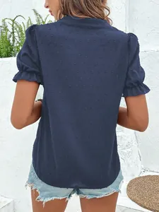 Vista trasera de una blusa de gasa azul marino con lunares suizos y mangas abullonadas