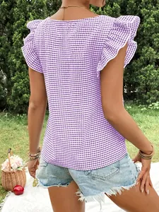 Back view of a purple gingham square neck blouse with ruffle sleeves in a garden