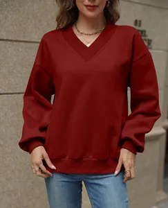 Detail view of the V-neckline and fabric texture of a burgundy oversized sweatshirt