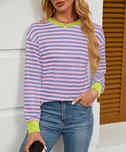 Detail of pink and blue striped crewneck long sleeve top with lime green cuffs