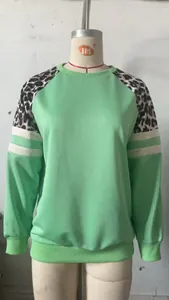 Vue détaillée d'un sweat-shirt vert menthe avec manches léopard et rayures blanches