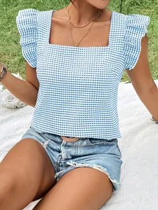Close-up of a blue gingham square neck blouse with ruffle sleeves in outdoor setting