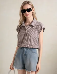 Detail van een bruine geruite blouse met korte mouwen en een casual reverskraag voor zomer.