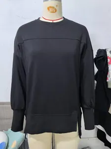 Détail du sweat-shirt noir à col rond avec fentes latérales et coupe décontractée