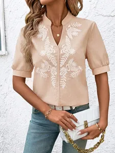 Close-up of beige cotton blouse featuring white floral embroidery and a stylish V-neckline