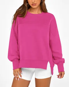 Détail du sweat magenta montrant la coupe décontractée et les fentes latérales