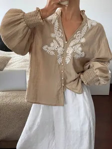 Detailansicht der beigen Bluse mit Stickerei und Perlenknöpfen für die Herbstmode