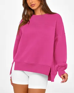 Vue détaillée d'un sweat-shirt rose surdimensionné avec fentes latérales et poignets.