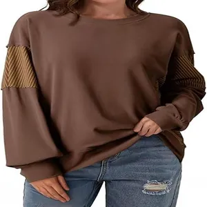 Close-up of brown long-sleeved sweatshirt featuring striped patchwork sleeve detail