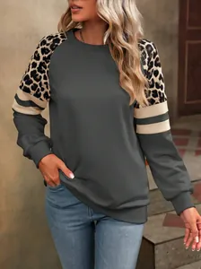 Détail d'un sweat gris foncé pour femme avec épaules léopard et manches à rayures.