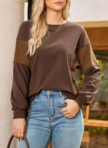 Detail of a casual crewneck sweatshirt with brown and yellow stripe patchwork design.