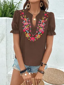 Vista detallada del bordado floral en la blusa marrón con cuello en V y mangas abullonadas