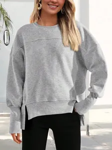 Détail d'un sweat-shirt gris ample avec des fentes latérales et de longs poignets côtelés