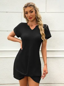 Primo piano di un mini abito nero con scollo a V caratterizzato da un elegante nodo intrecciato