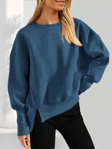 Détail de la fente latérale sur un sweat-shirt bleu à col rond décontracté et ample