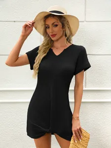 Dettaglio dell'abito da spiaggia nero con scollo a V da donna e nodo intrecciato.
