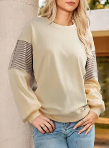 Detailed view of fashionable cream sweatshirt with striped sleeve and side paneling