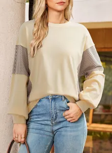 Detailed view of casual beige crewneck sweatshirt with stylish striped patchwork panels