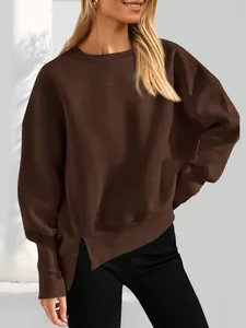 Détail de la fente latérale sur un sweat-shirt à col rond marron surdimensionné à manches longues