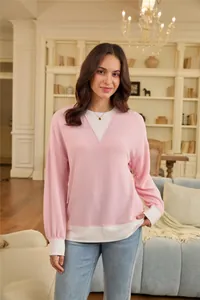 Casual pink and white color-block sweatshirt with ribbed texture on a model indoors