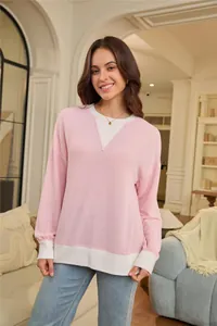 Detailed view of the ribbed knit texture on a loose pink and white color-block sweatshirt.