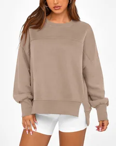 Détail d'un sweat-shirt taupe à col rond, manches longues et fentes latérales élégantes.