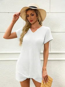 Vista dettagliata del miniabito bianco in maglia a nido d'ape con scollo a V e nodo frontale