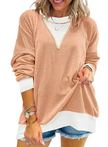 Close-up detail of textured color-block sweatshirt showing waffle knit fabric and cuffs