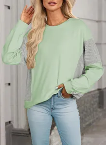 Detail view of a mint green casual sweatshirt with stylish striped patchwork panels