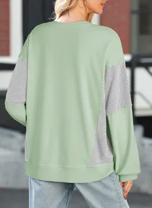 Back view detail of a fashionable light green striped patchwork casual crewneck sweatshirt.