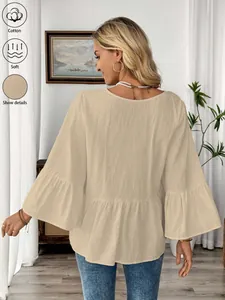 Rückenansicht eines beigen V-Ausschnitt Baumwolltops mit eleganten Rüschenärmeln zu Hause