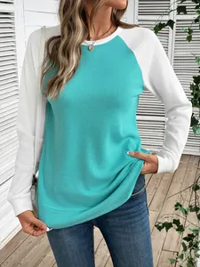 Détail rapproché d'un haut pour femme en maille gaufrée bicolore bleu sarcelle et blanc