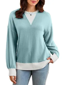 Close-up of light blue ribbed knit sweatshirt with color-block white trim details