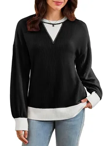 Detail view of woman wearing a black and white color-block waffle knit sweatshirt.