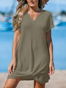 Dettaglio macro del tessuto a nido d'ape e del nodo sull'orlo di un abito da spiaggia kaki