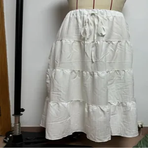 Close-up detail of a white tiered bohemian maxi skirt with a comfortable drawstring waist.