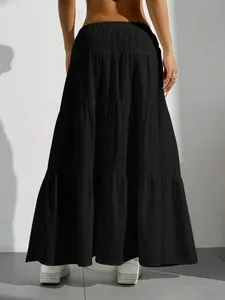 Detail showing the back view of a black tiered maxi skirt with vertical pleated fabric texture
